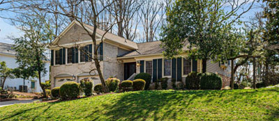 Light brick large 2 story home with garages on a hill